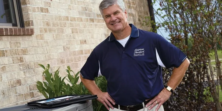 american-standard-dealer-stand-next-to-hvac-unit