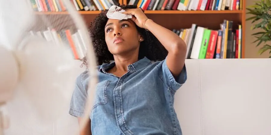 woman-sitting-on-sofa-in-front-of-fan